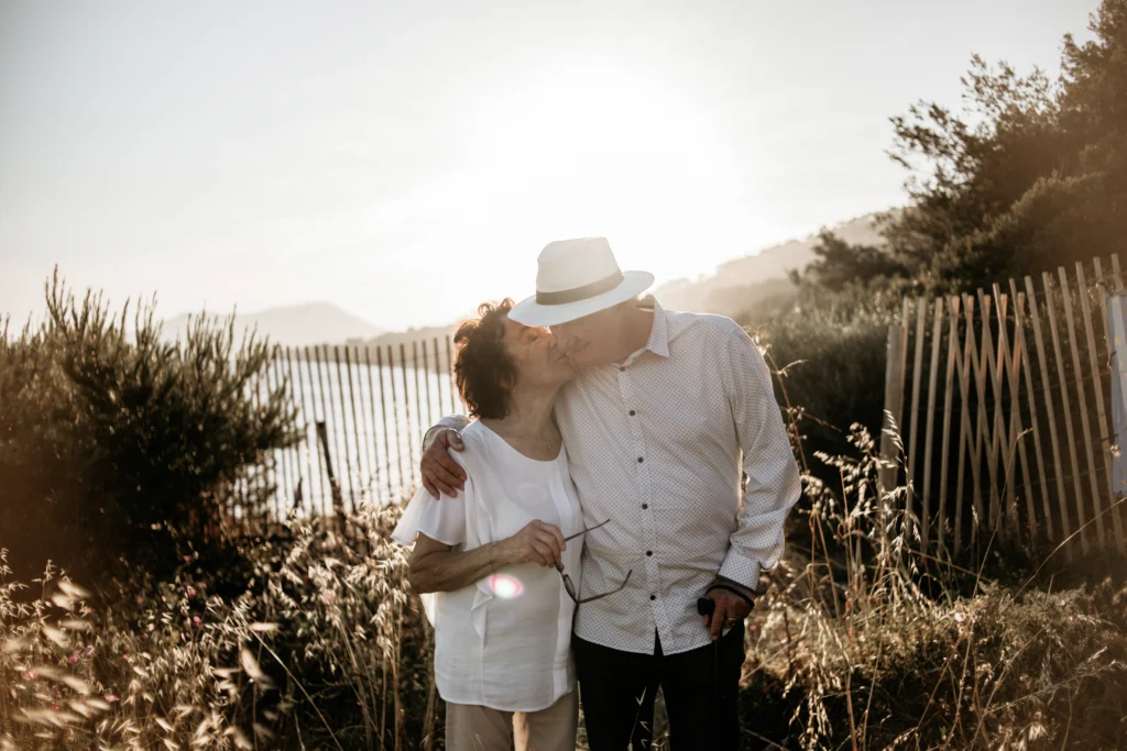 Couple âgé s’embrassant tendrement au coucher du soleil dans un décor naturel. Photographe mariage Provence, Luberon, Côte d'Azur et portraits naturels