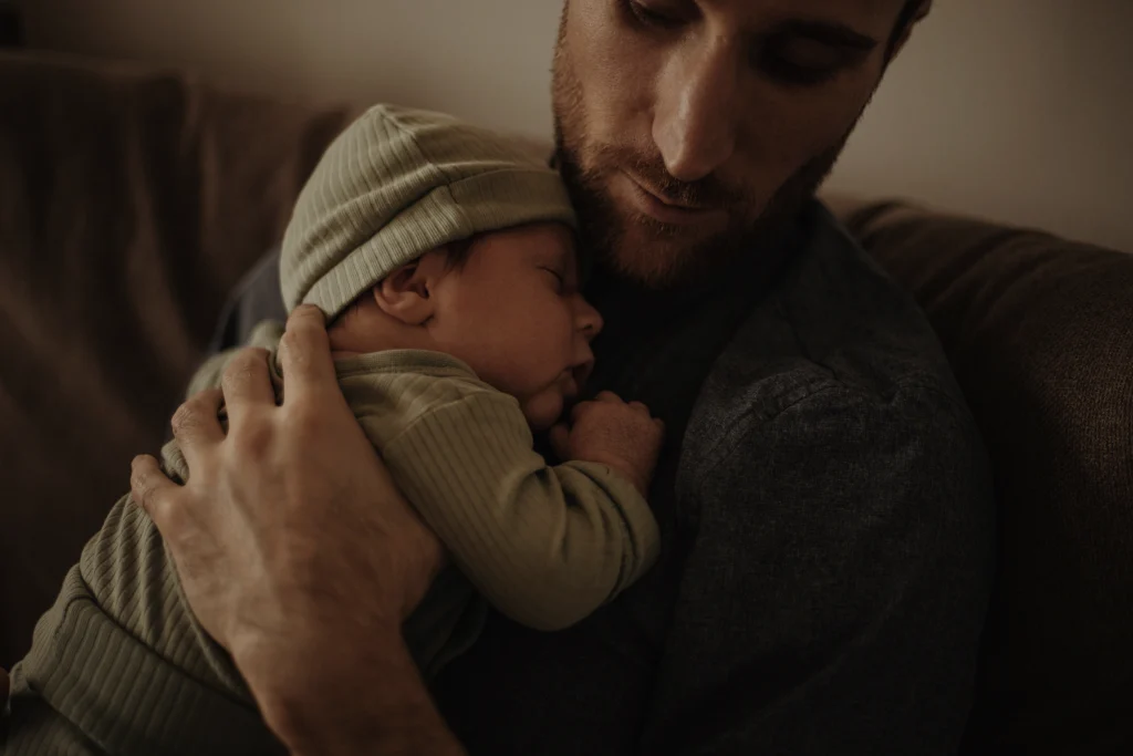 Séance photo naissance, un moment de complicité entre un père et son bébé.