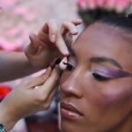 Une maquilleuse varoise en train d'appliquer du mascara sur l'une des mannequins d'un défilé de mode locale.