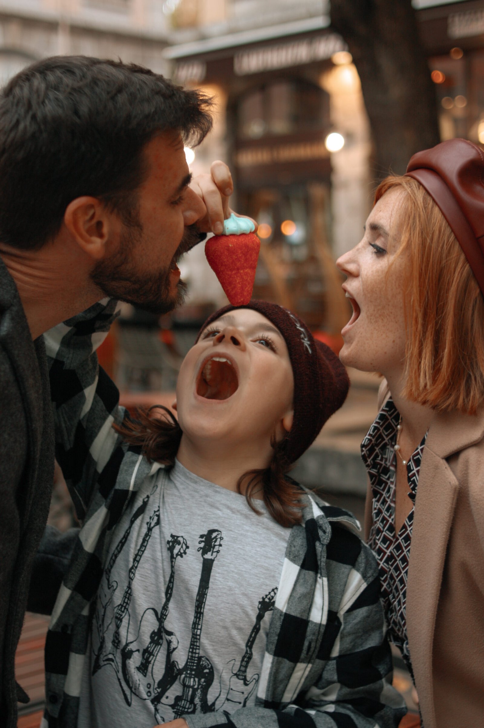 Une famille de trois, partageant un bonbon géant dans les rues d'Aix-en-Provence pour leur séance photo en famille.