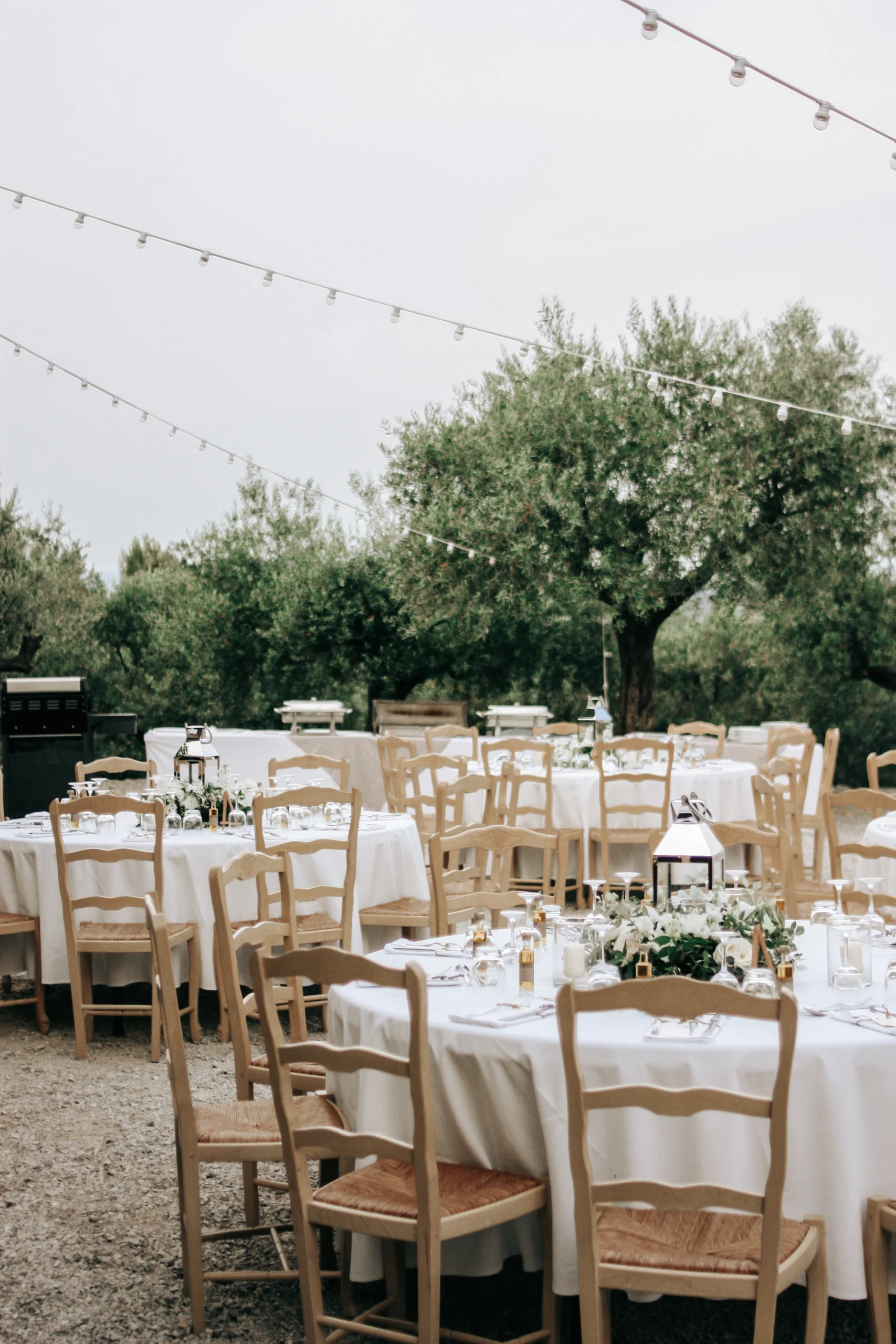Tables joliment décorées pour un repas de mariage sous les oliviers. Photo par Nolwenn Biannic photographe mariage naturel et discret provence.