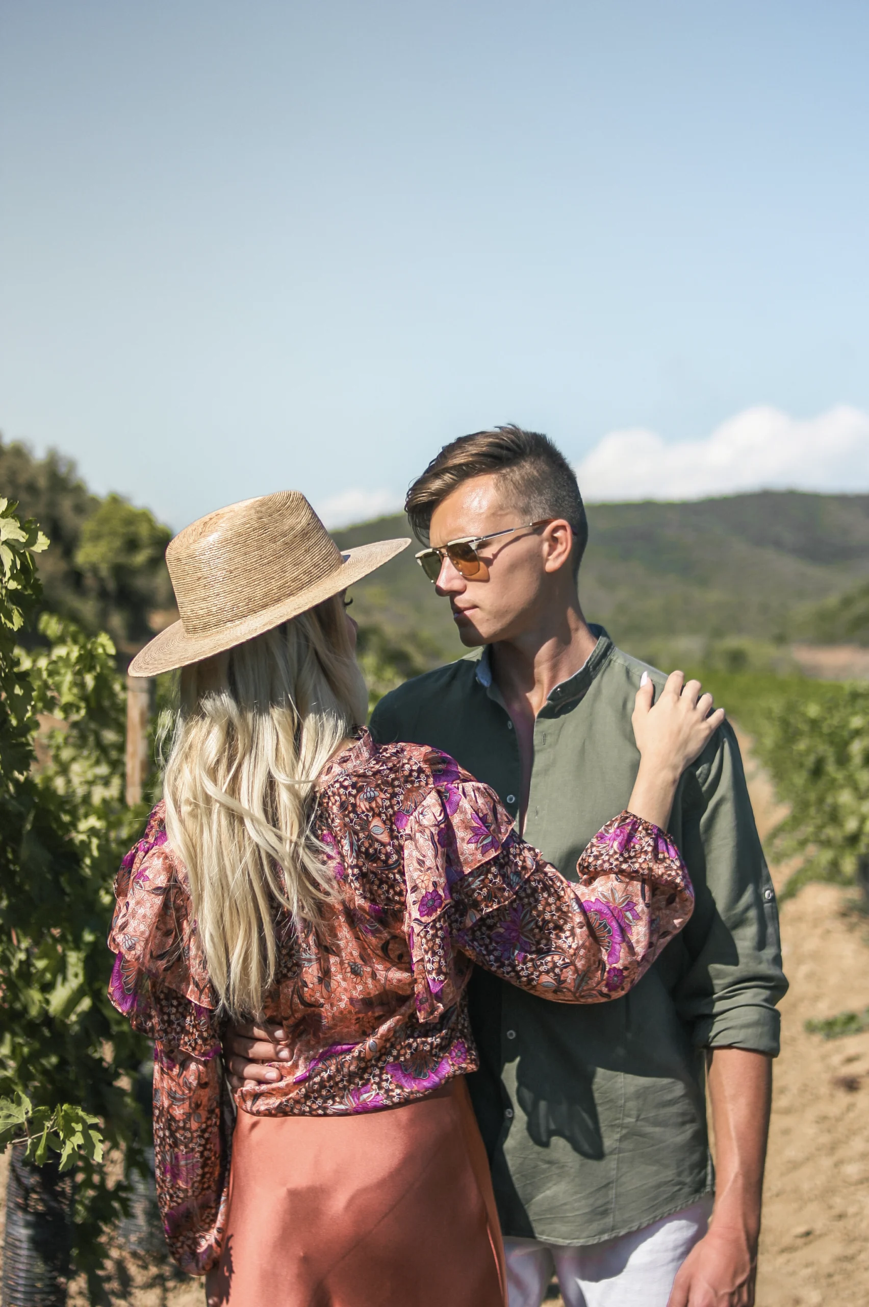 Un couple dans un champ de vignes, à Bormes-les-mimosas, se regardant amoureusement sous le soleil du sud de la France.