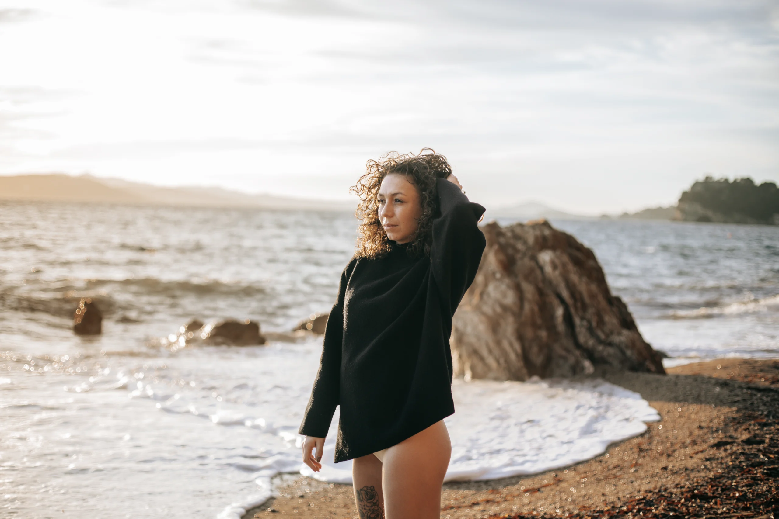 Une jeune femme, debout sur une plage de Hyères, lors d'un shooting confiance en soi.