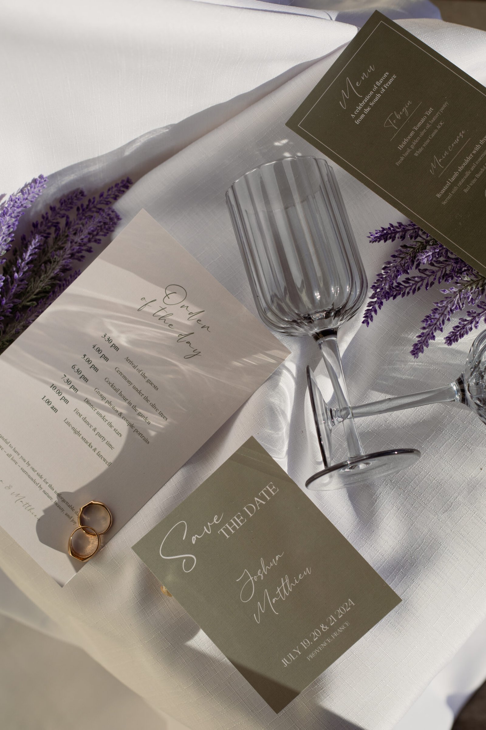 Flatlay de mariage sur le thème de la Provence, dans les tons vert sauge et vert olive, accompagné de Lavande. On y retrouve deux alliances, deux verres à pied vintages.