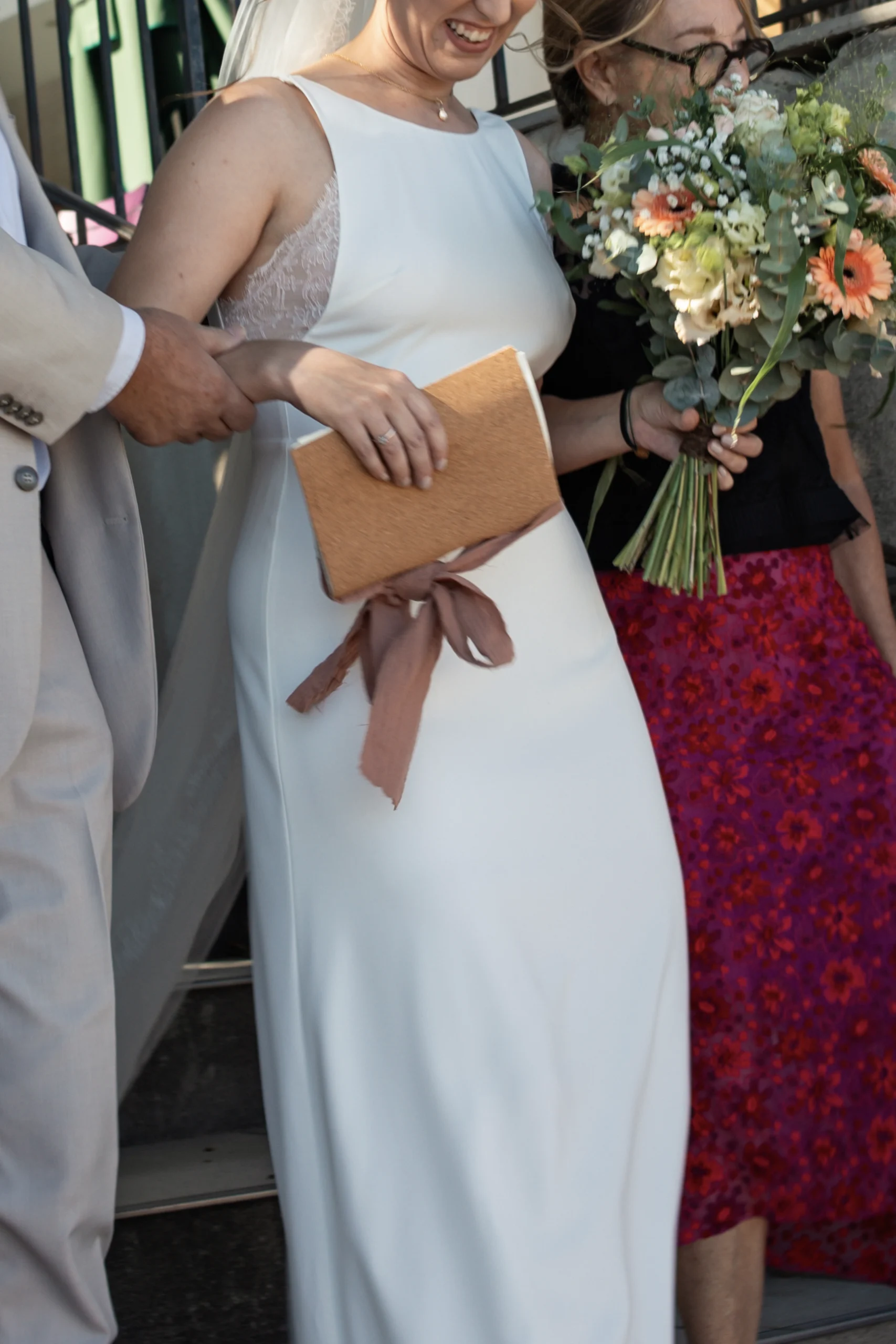 La mariée arrivant à sa cérémonie laique en Provence, accompagnée de ses parents. La photos met en avant son livre de voeux.