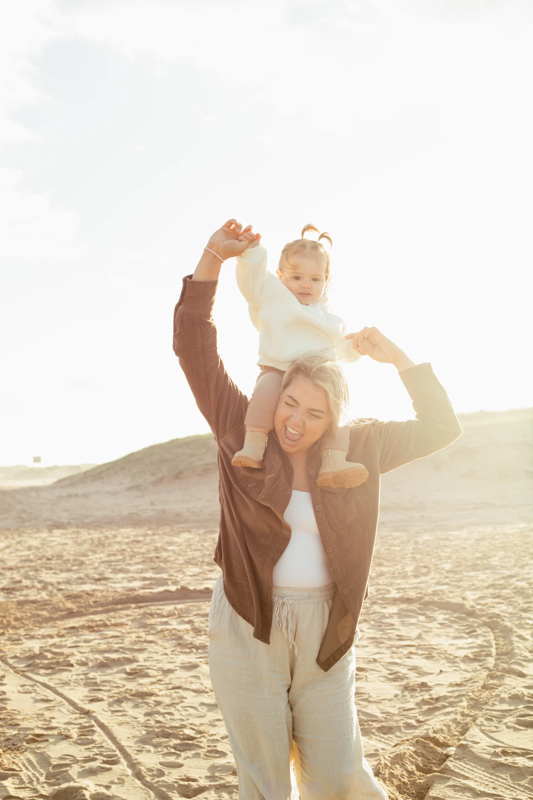 Une mère porte sur ses épaules sa fille en bas âge. Elle rit ensemble.