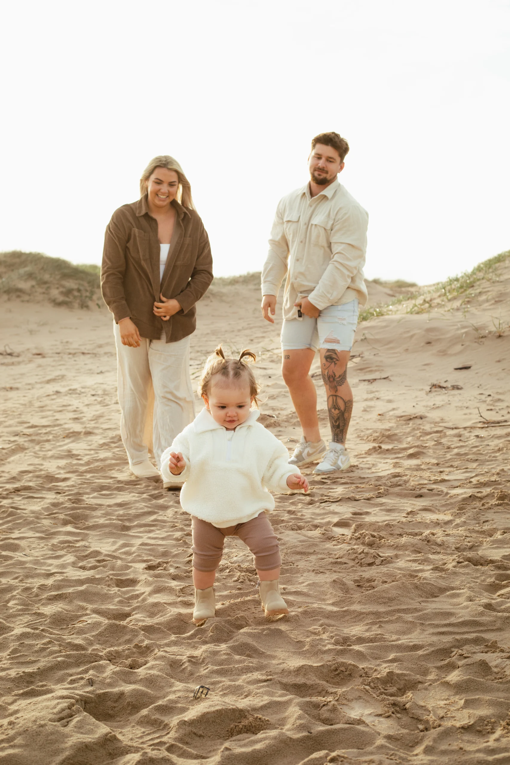 Deux parents, courant derrière leur petite fille sur la plage. Une séance photo en famille pleine d'émotions dans le Var.