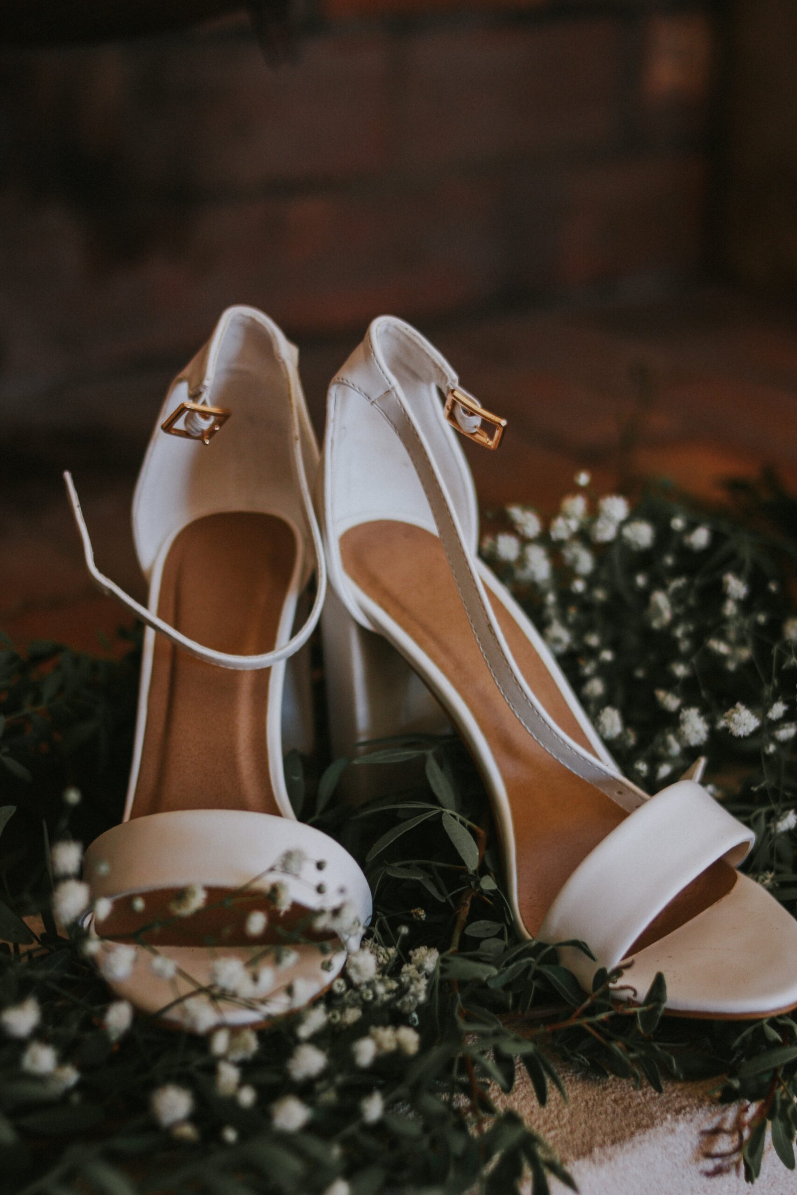 Les chaussures de la mariée, disposées sur un tapis végétal.