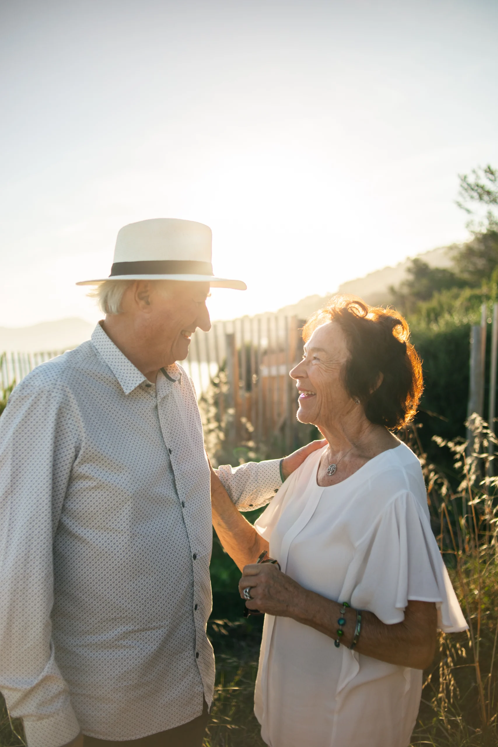 Une séance photo au coucher du soleil avec un couple sénior à Hyères. ils se regardent amoureusement et en riant.