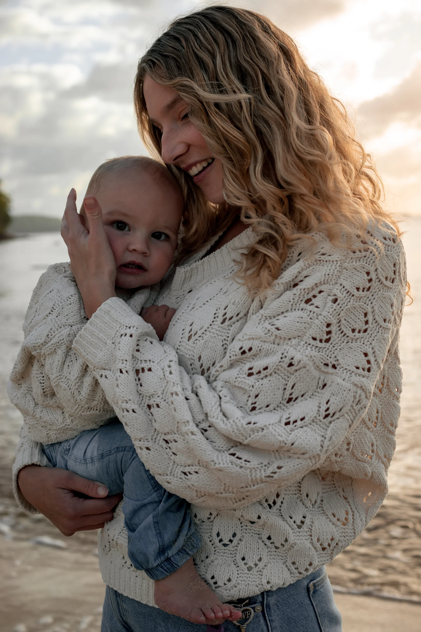Une mère, serrant dans ses bras son fils d'un an. Un moment tendre en bord de mer à Hyères.