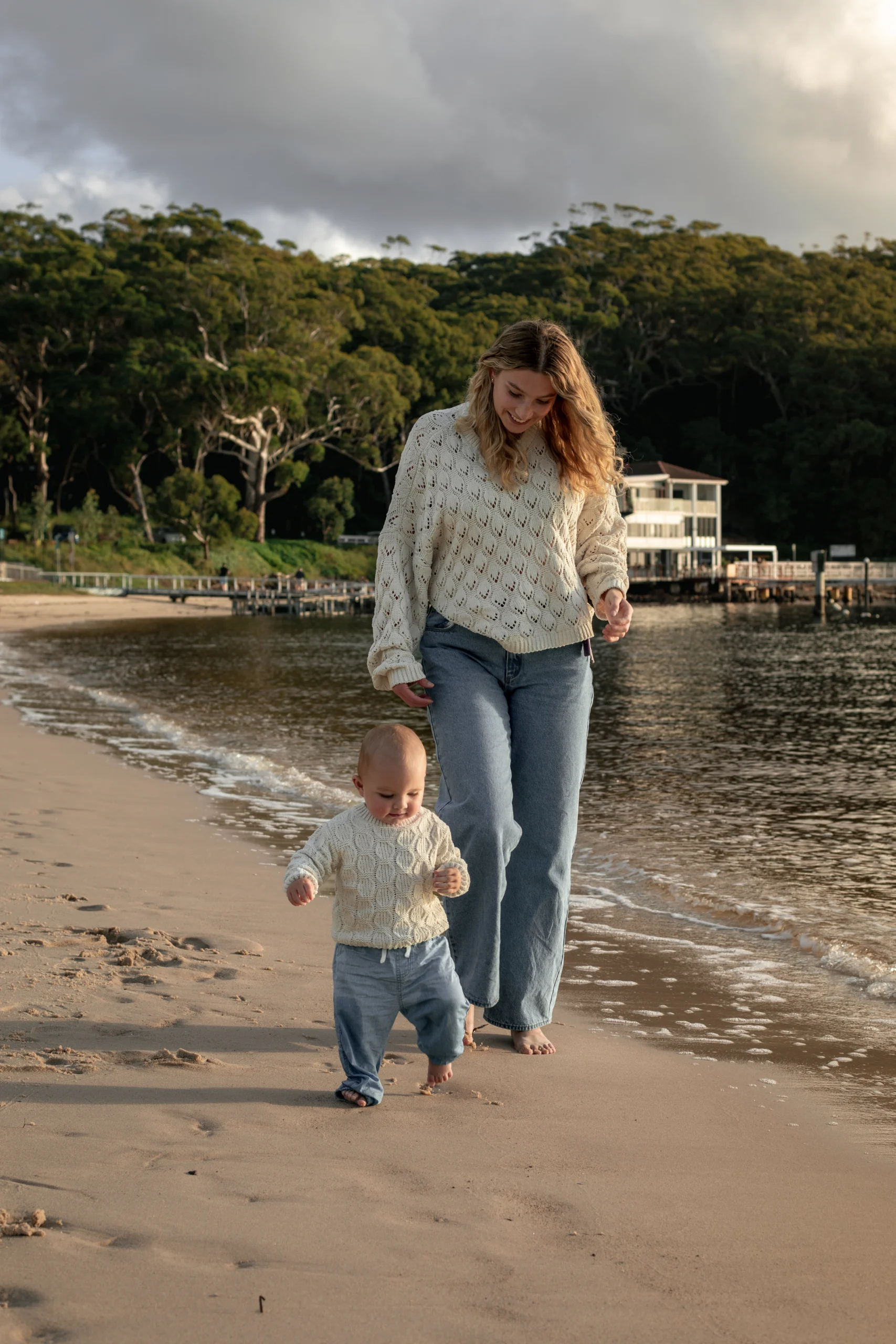 Une jeune mère marche avec son fils au bord de l'eau, sur la plage.