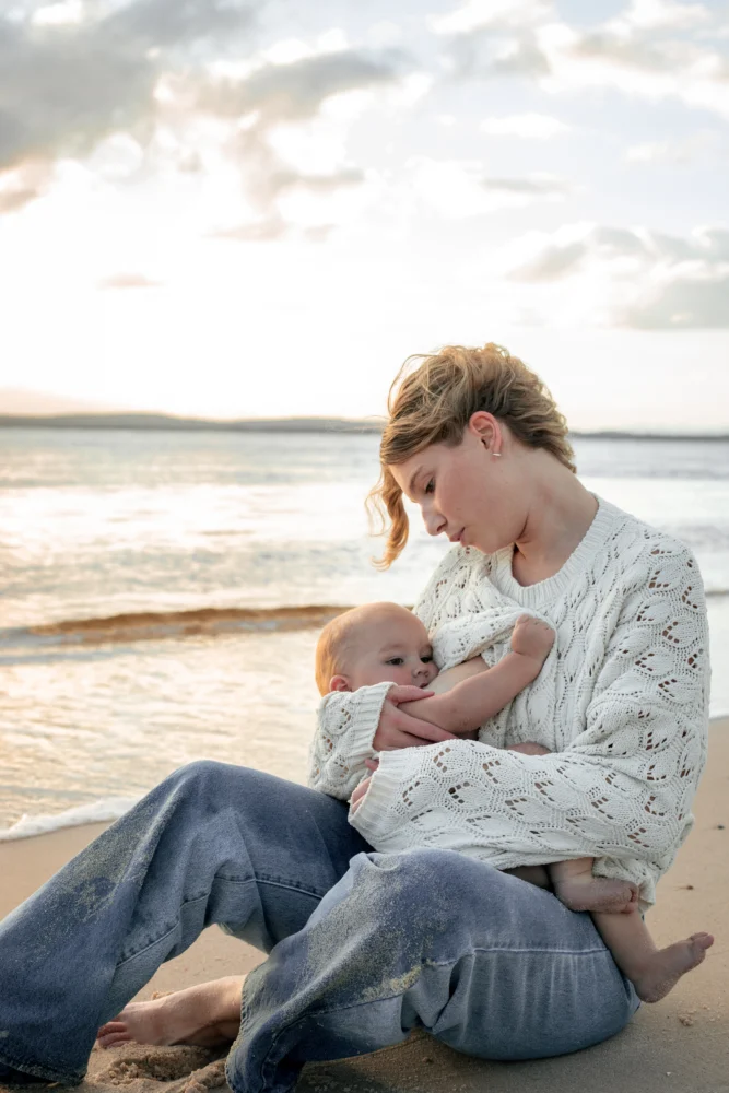 Une mère qui regarde avec amour son bébé pendant qu'elle l'allaite.