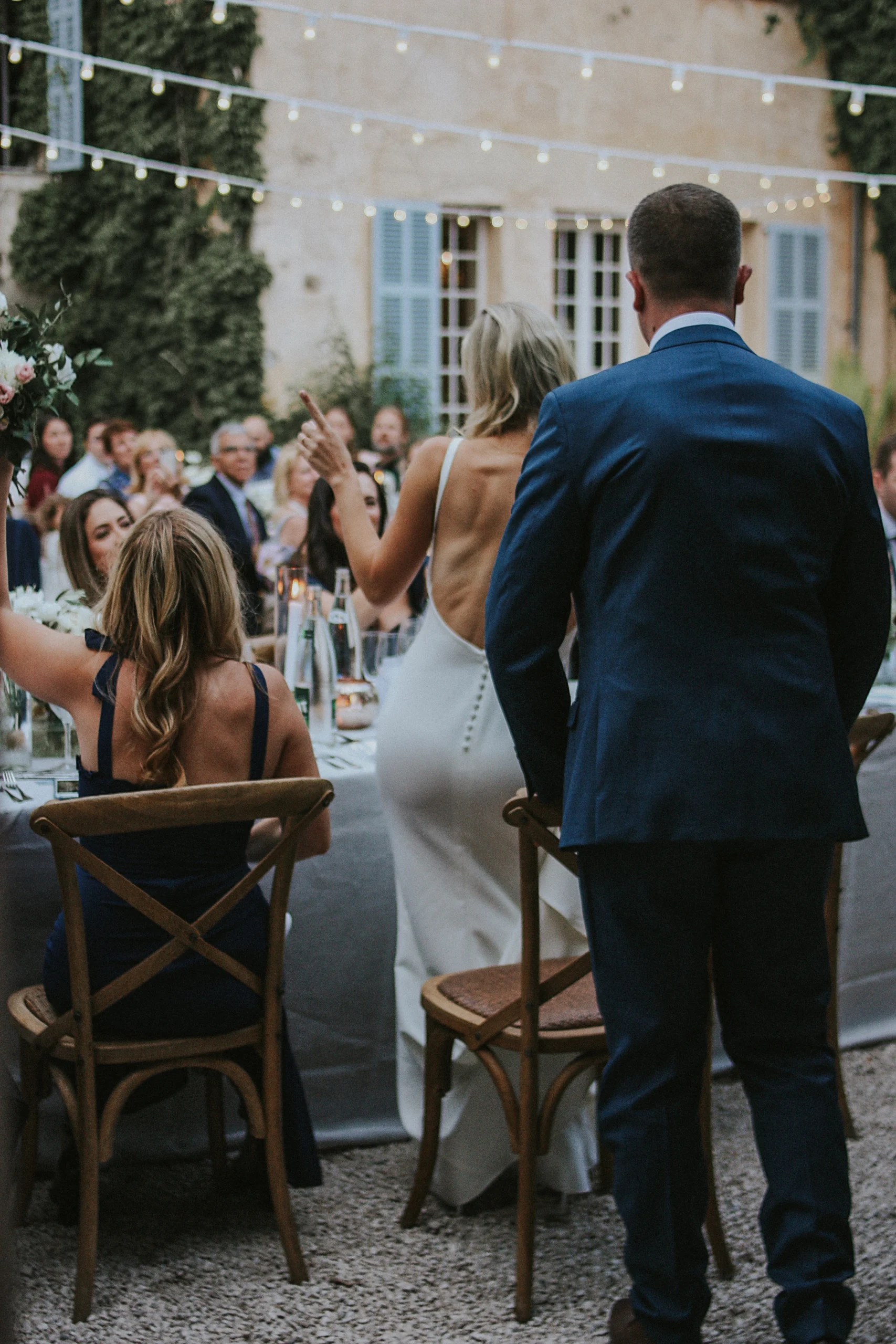 Une mariée, dansant à la table d'honneur, entourée de ses amis. Une photo naturelle et pleine de vie, réalisée par une photographe de mariage documentaire en Provence.