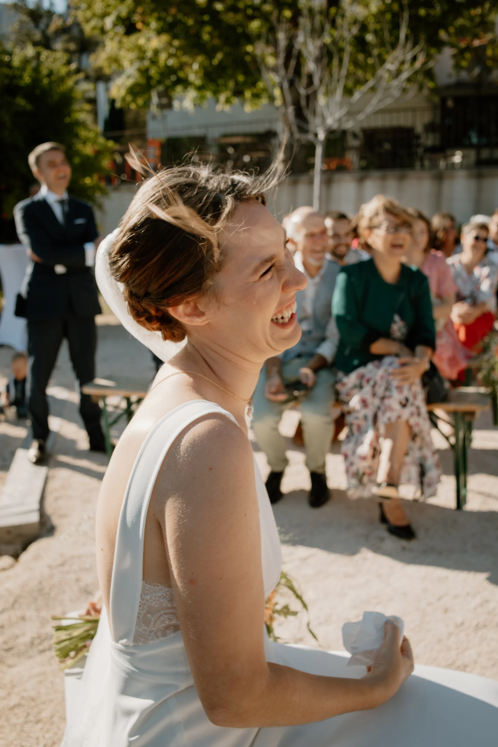 Une mariées, riant et pleurant d'émotions, lors du discours de son époux durant une cérémonie laique au Relais de St Ser. Un mariage en Provence.