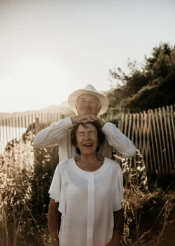 Un couple lors d'une séance photo au sunset dans le Var. La femme est vêtue d'un chemisier blanc léger et l'homme d'une chemise blanc cassé et d'un chapeau.